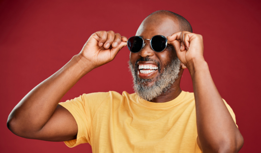 A man smiling and wearing sunglasses.