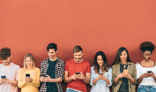 A line of people each holding a phone and looking at it.