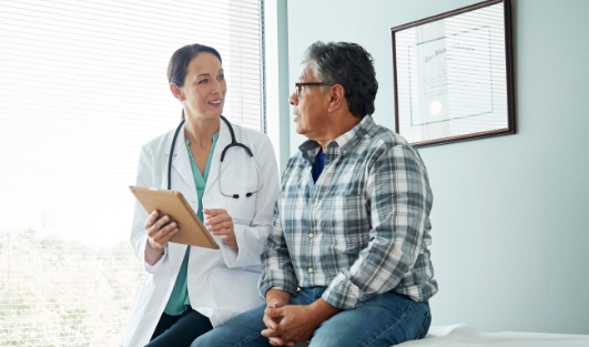 A doctor seeing a patient and going over paperwork.