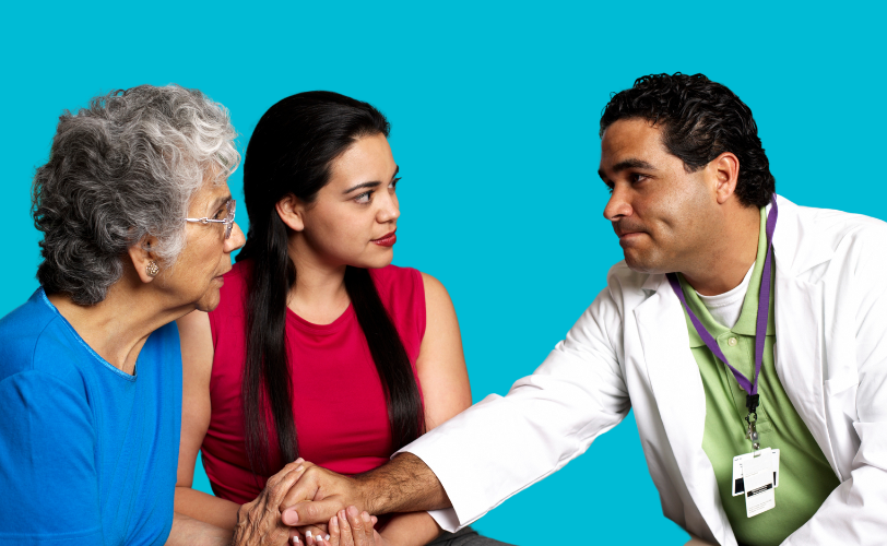 A healthcare professional sitting with a younger woman and an older woman.