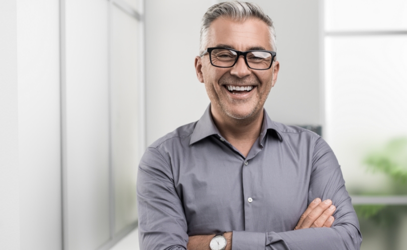 A man smiling with his arms crossed.