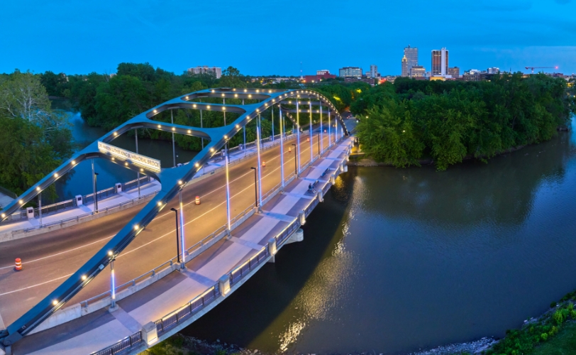 A big bridge across the water lit up, and a city off in the distance.