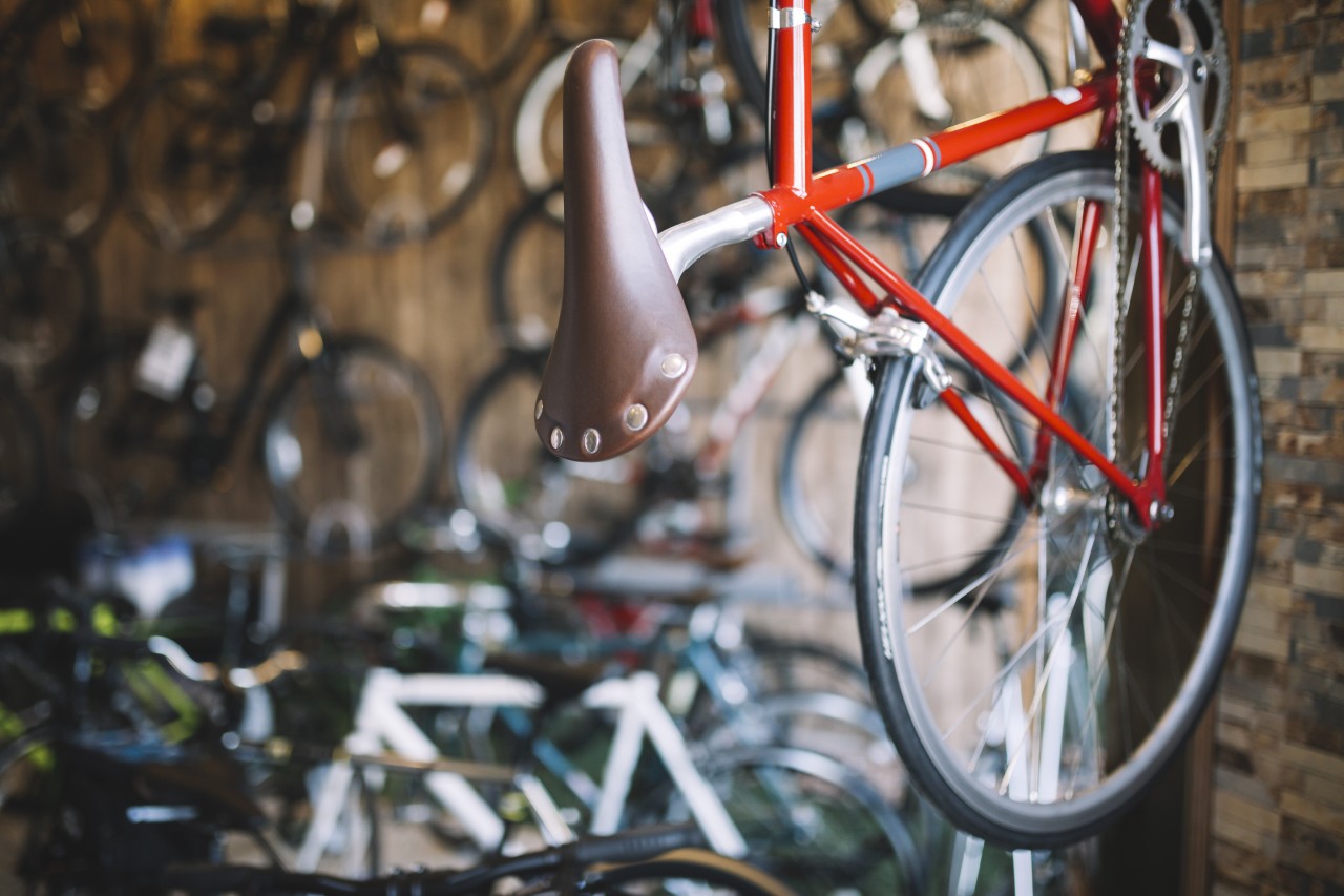 A bike shop's display of bikes hanging from the wall and on the floor.