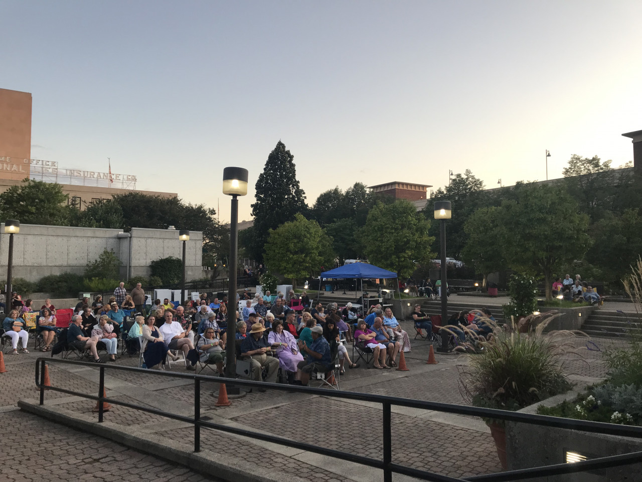 People sitting outside in the terrace garden listening to music.