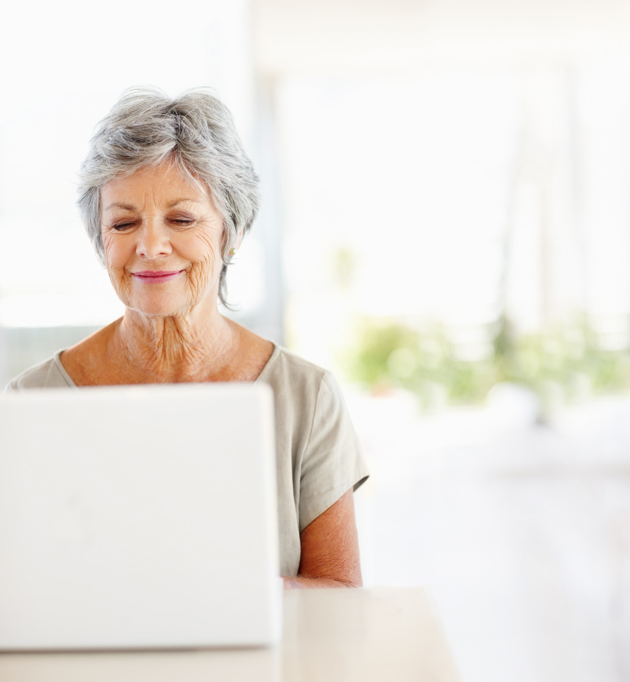 A happy mature woman on a laptop.