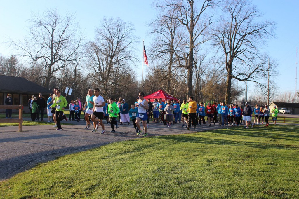 Race participants walking/jogging on a path to the finish line.