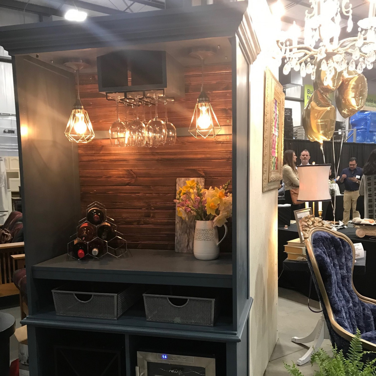 A homemade kitchen cabinet with a wine rack, lights, and drawers.