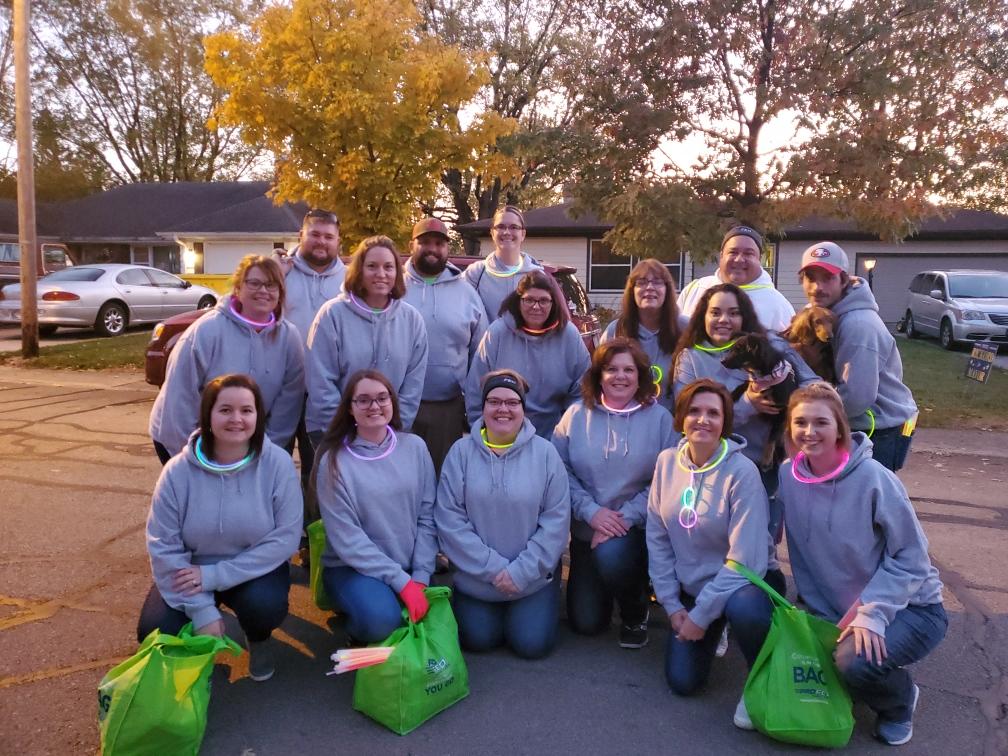 A group of people huddled together ready to pass out candy in a parade.