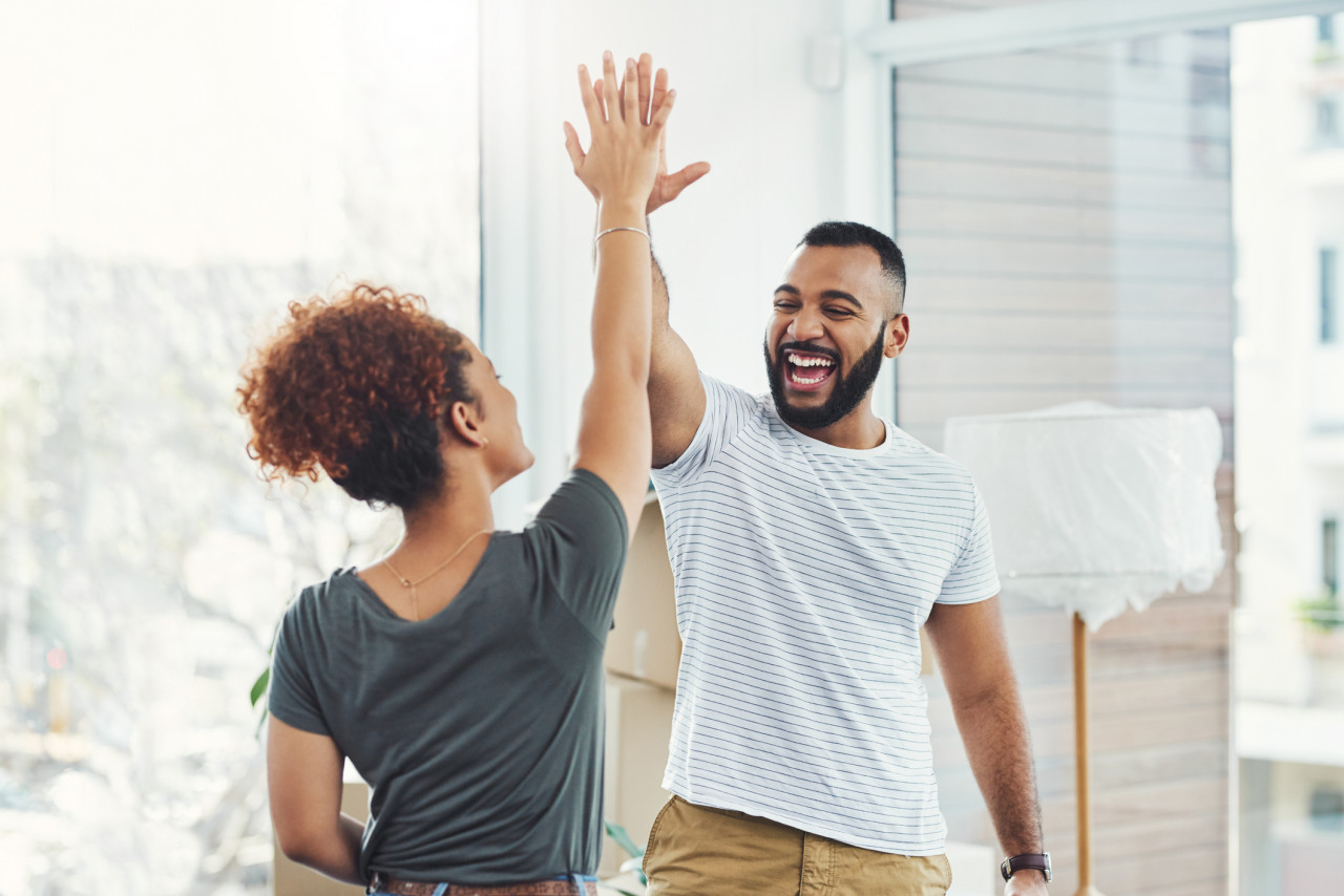 Couple high five in their new home.